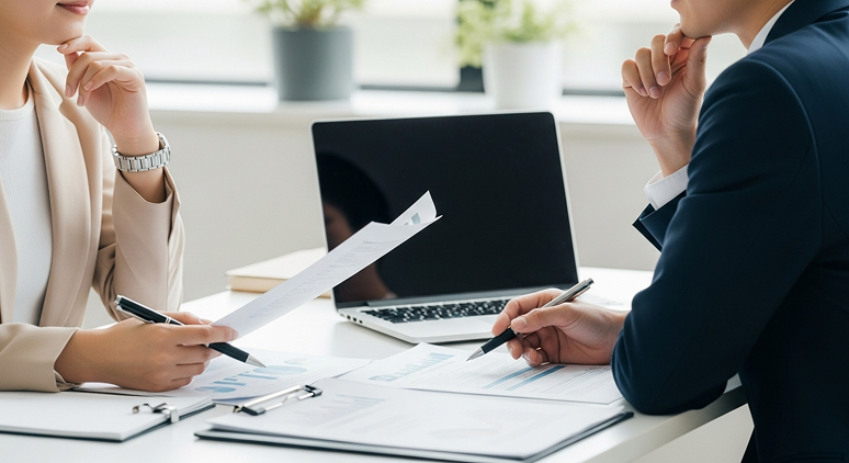 資料を見ながら課題について打ち合わせをするビジネスシーン